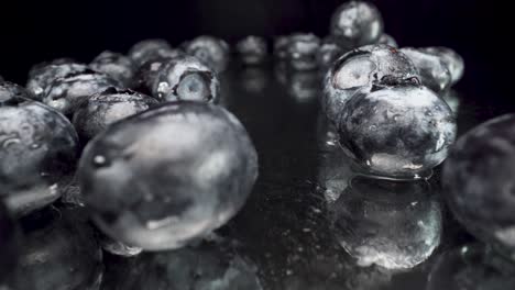 macro view flying past wet blueberries on reflective glass with black background, amazing shot selective focus