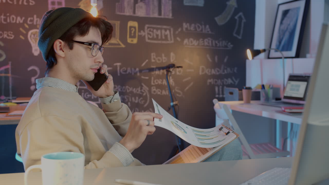 Young man working from home and having a phone call.