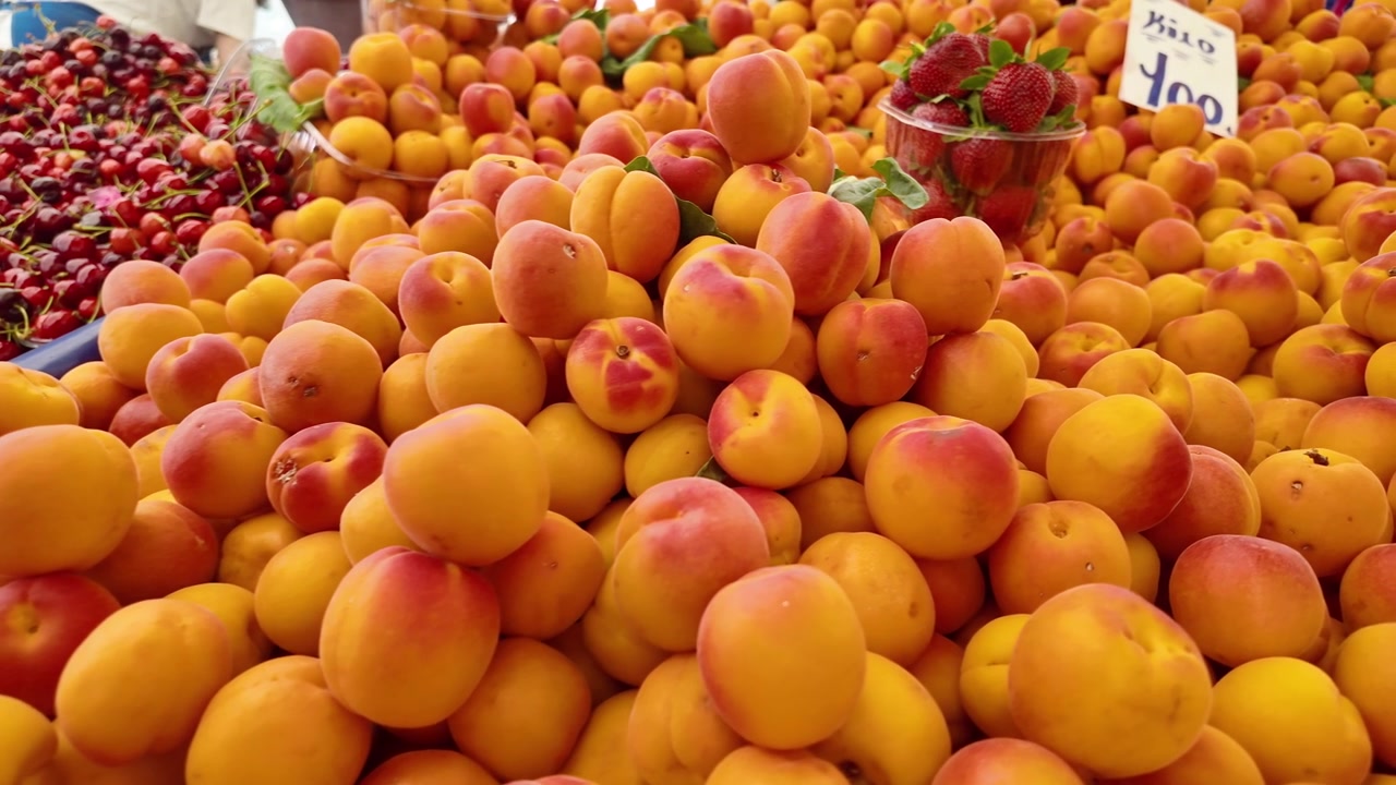Gros plan sur des abricots frais et mûrs et des cerises sur un marché