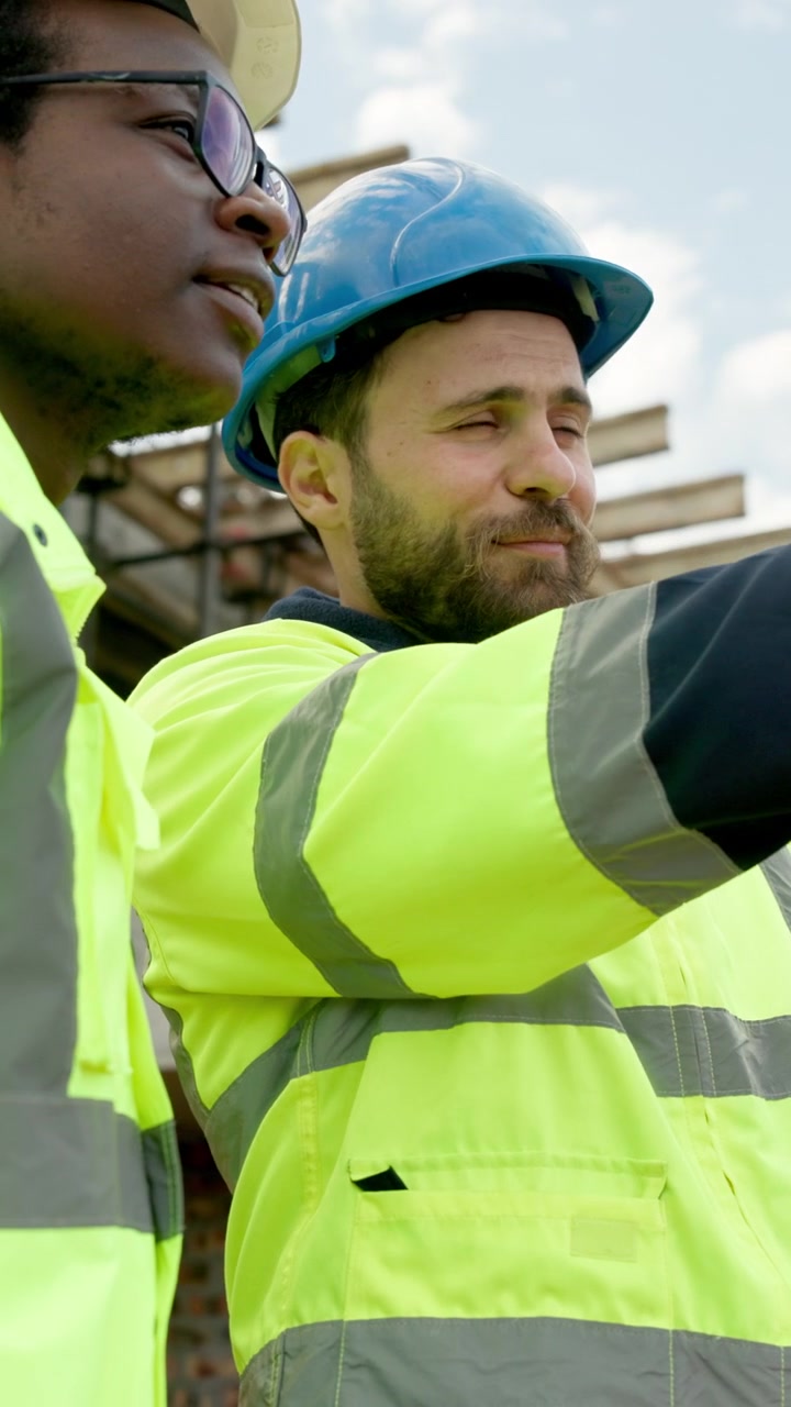 Construction Workers Discussing Project Plans at Building Site