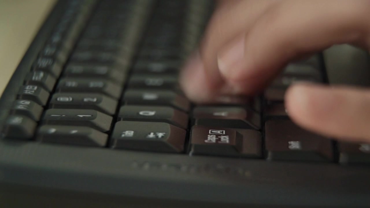 Hands of worker using typing on keyboard, close up side view