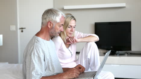 Paar-Mit-Laptop-Zusammen-Im-Schlafzimmer