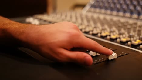 ingeniero de audio masculino usando mezclador de sonido en un estudio de grabación
