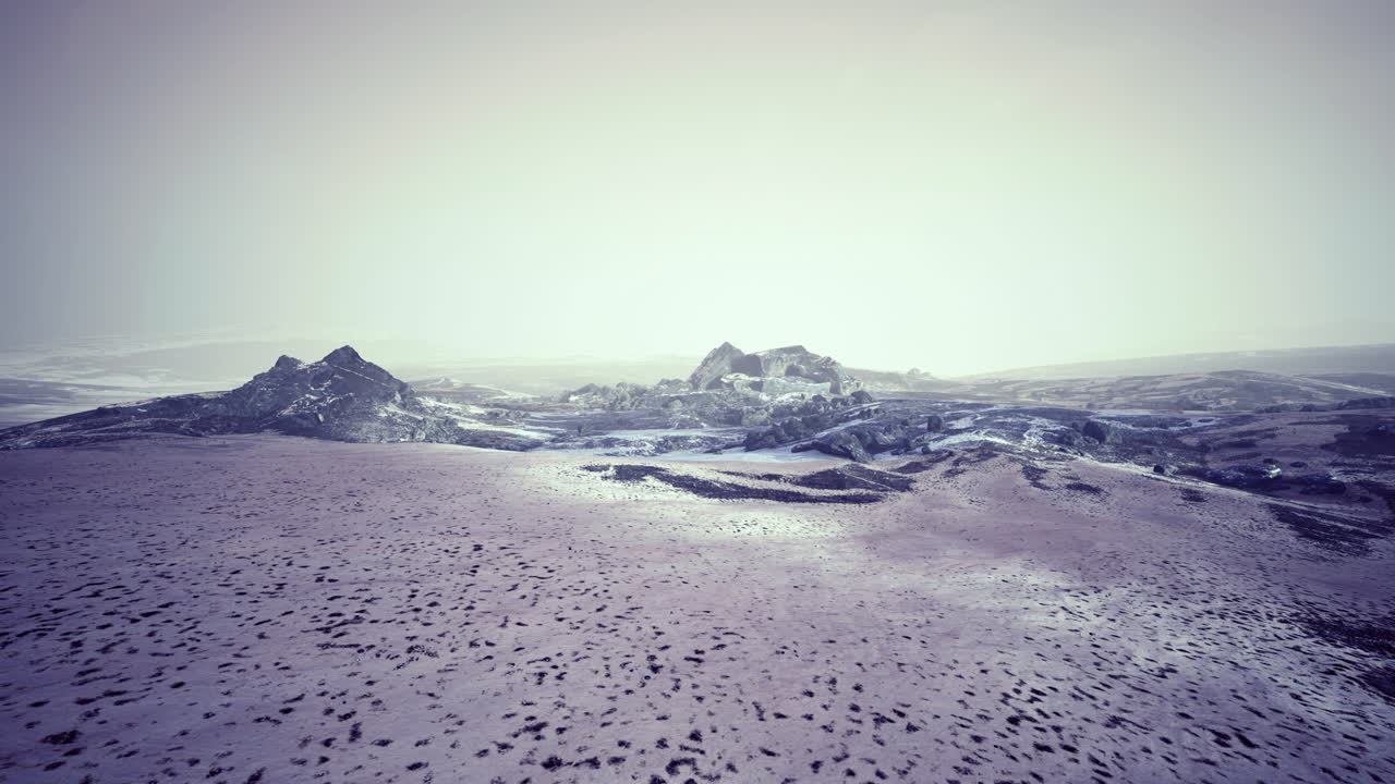 Snowy mountain landscape with fog covering rocky peaks during winter