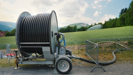 watering the wheat field in the foreground is a large coil with a water hose agriculture in norway 4