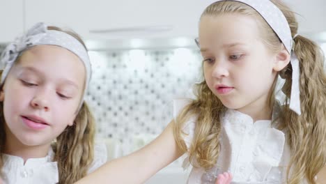 two young girls baking in the kitchen