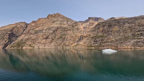 view of small iceberg and mountains in prince christian sound in greenland