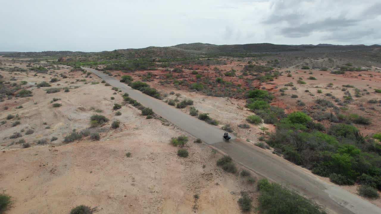 Desert road with lone motorcycle ride in vast, open landscape