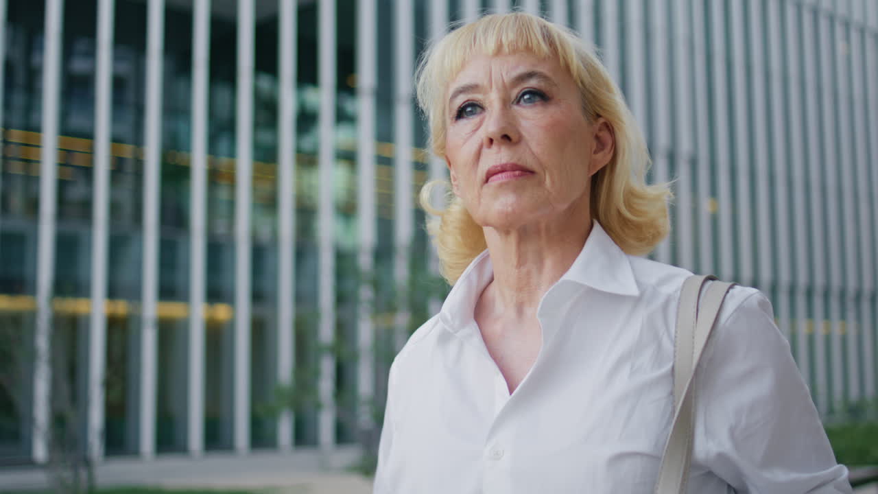 Beautiful elderly woman going at town area hurrying on business meeting close up
