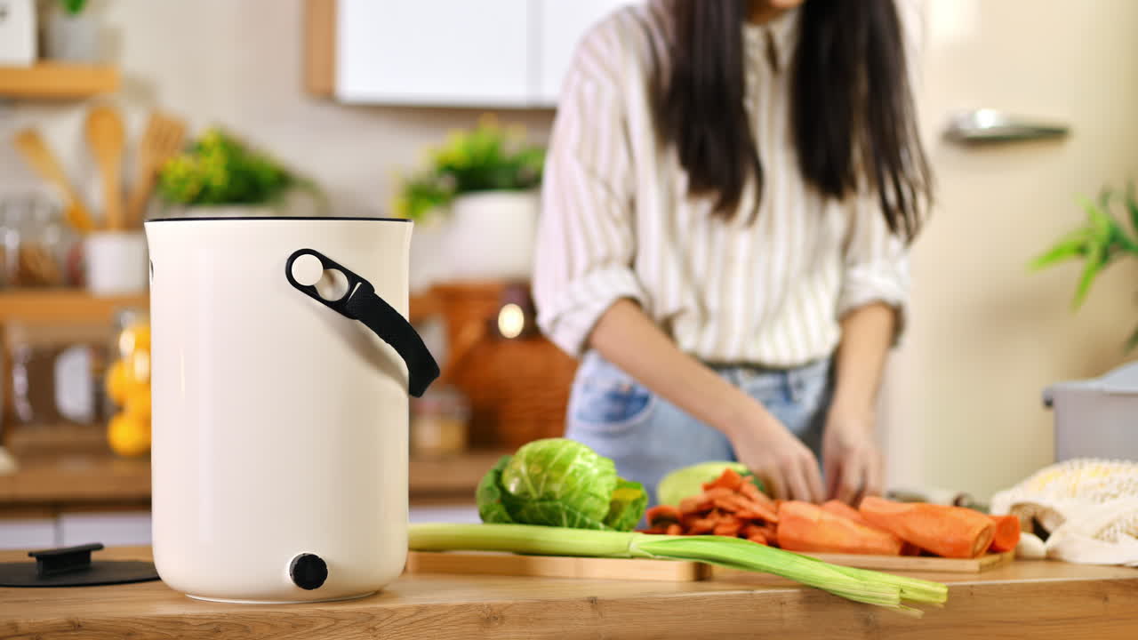 Young woman recycling vegetables peels in a compost bin. Housewife cooking food and composting organic waste in a bokashi container at home. Ecological and sustainability concept