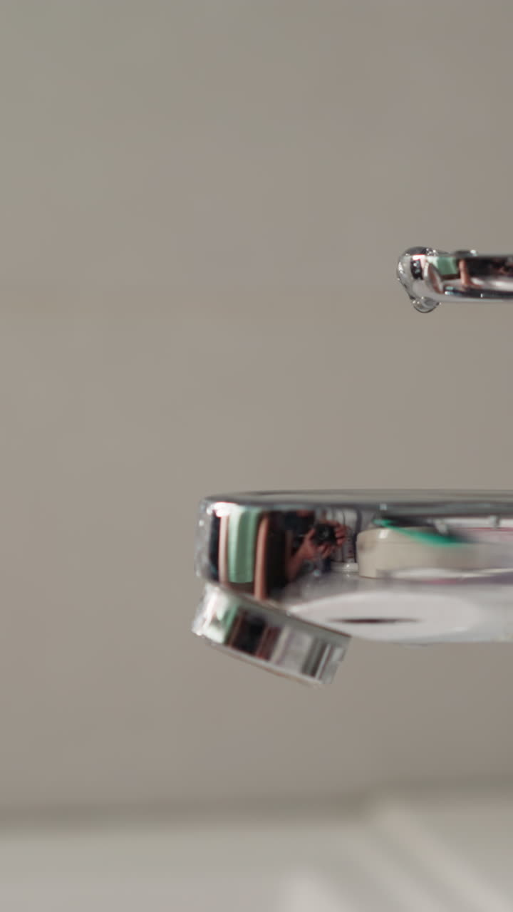 Young woman washes hands under running water slow motion. Female closes faucet after performing hand hygiene in light bathroom closeup. Daily routine