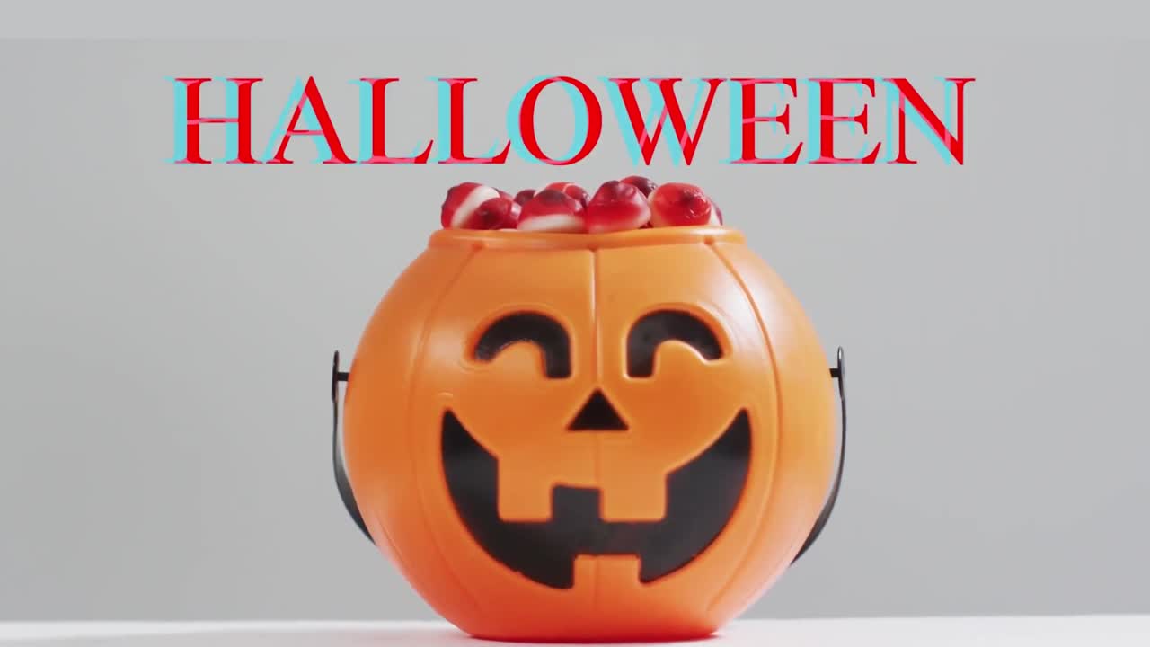 animación del texto de halloween sobre un cubo de calabaza tallado con dulces sobre un fondo gris