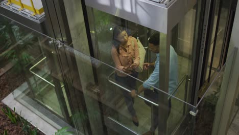 video of diverse businesswoman and businessman talking in elevator