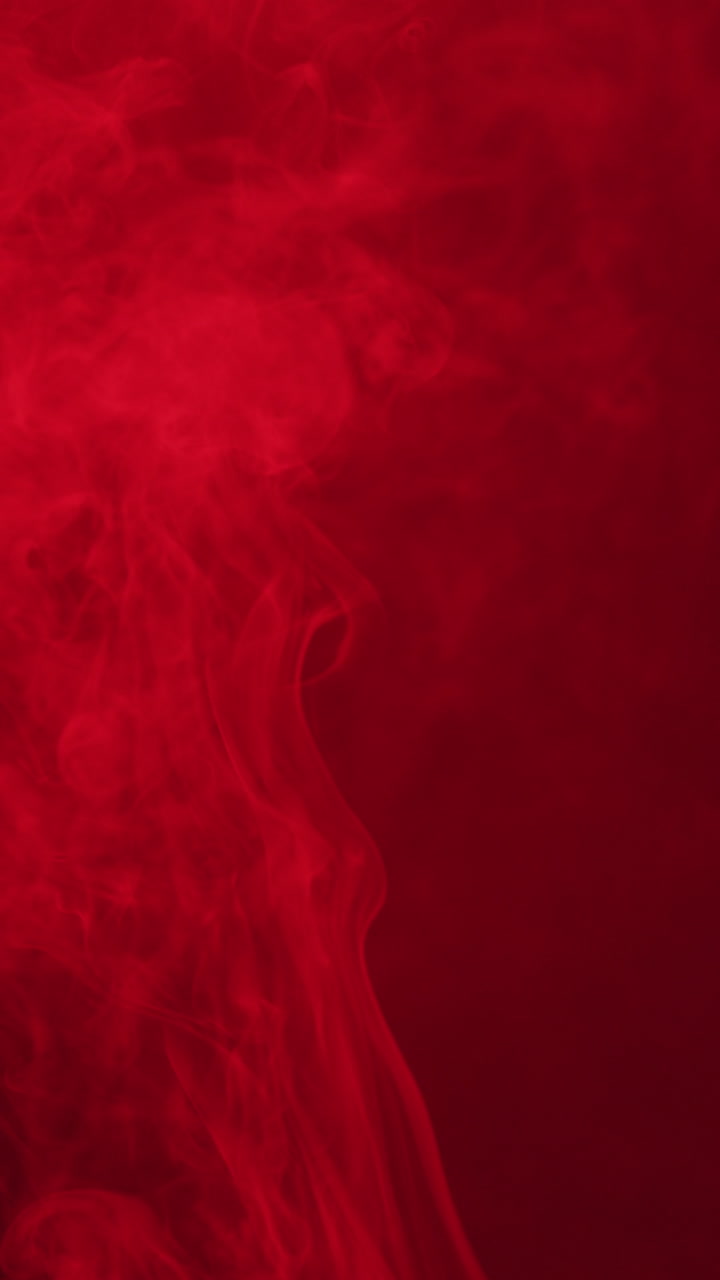 검은 바탕에 움직이는 빨간 빛과 함께 색 연기의 수직 비디오