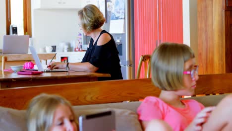 woman using laptop in kitchen 4k