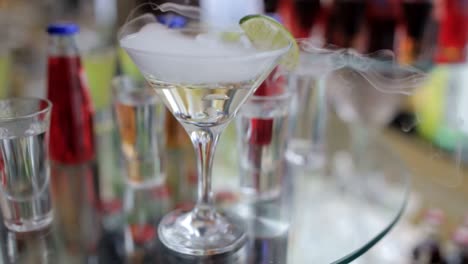 smoking martini cocktail in a conical glass with wafting vapor smoking martini cocktail in a conical glass with wafting vapor