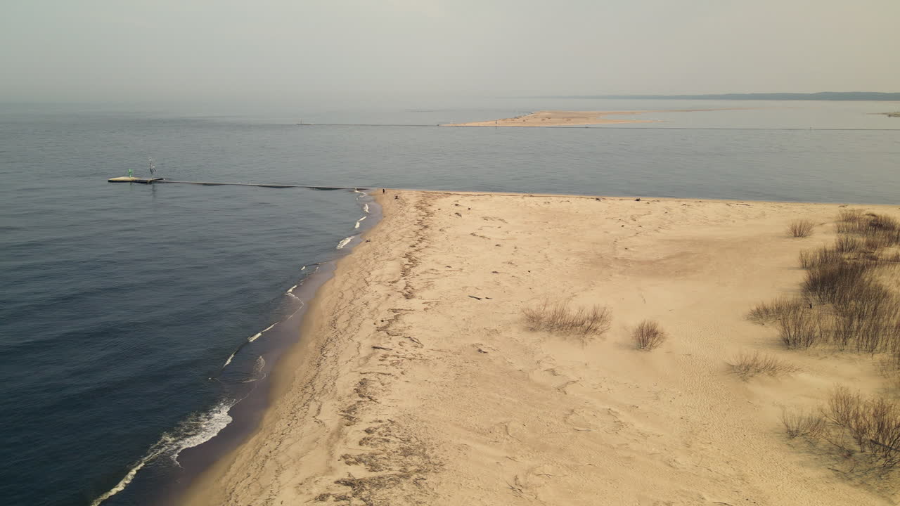 폴란드의 비스툴라 강에서 강 입으로 모래 해안에서 끝나는 작은 파도를 보여주는 공중 트럭 샷