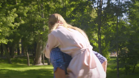 couple enjoying a piggyback ride in a park