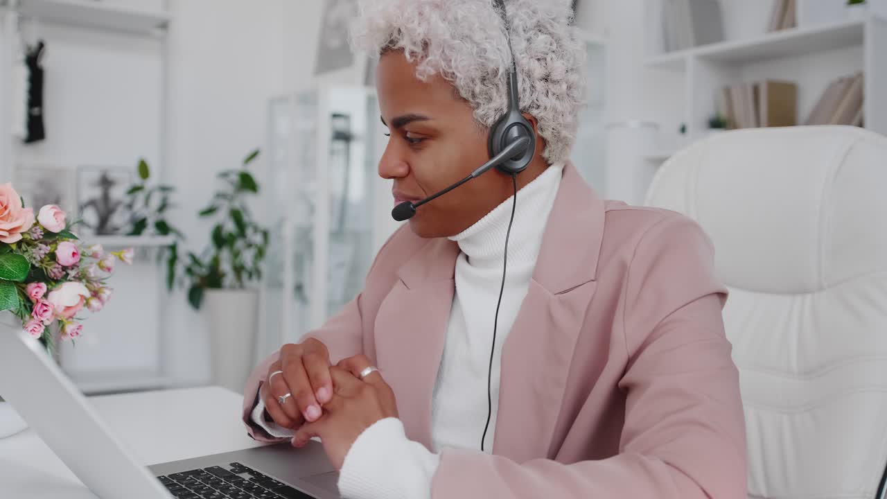 Young hispanic business woman wearing headset communicating by video call