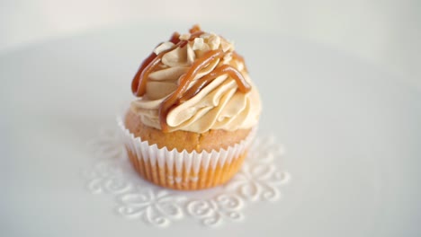 Una-Magdalena-De-Muffin-Con-Sabor-A-Cacahuete-Que-Gira-Lentamente-En-Un-Plato-Blanco-Decorado