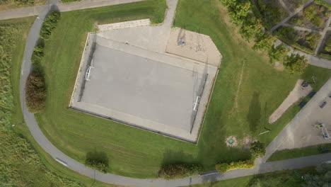 Blick-Von-Oben-Auf-Einen-Fußballplatz-Aus-Beton-Auf-Einem-Spielplatz-In-Einem-Vorort---Drohne-Hebt-Sich-Und-Dreht-Sich