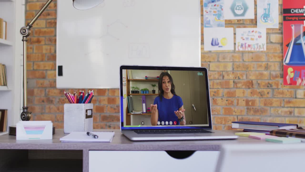 vista de webcam de una maestra afroamericana en una videollamada en una computadora portátil en la mesa de la escuela