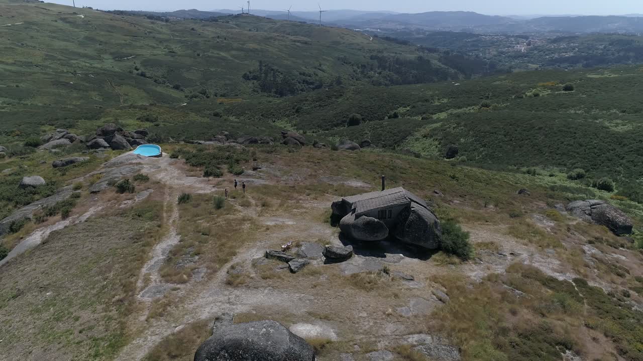 vista aérea de la casa en las montañas con molinos de viento