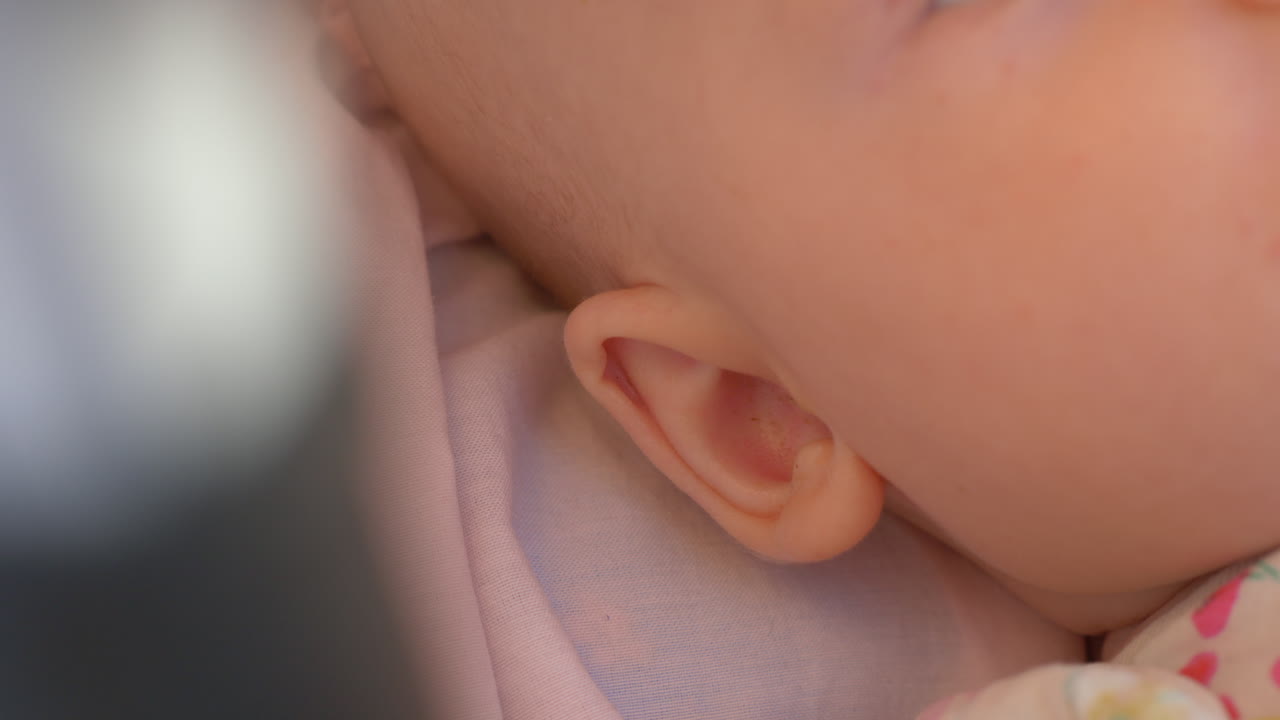 아기 소녀가 아기차에 누워서 움직이고 있다