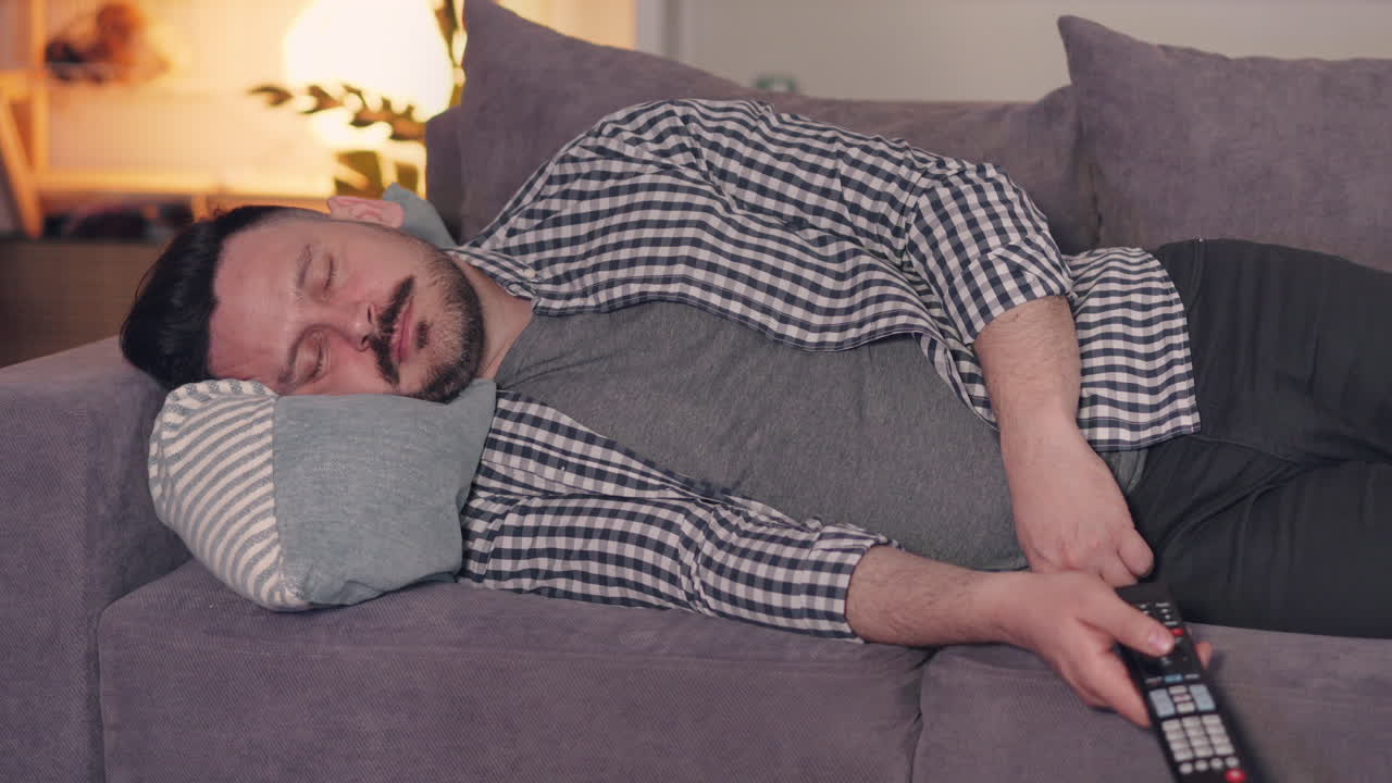 Man Sleeping on Couch with Remote