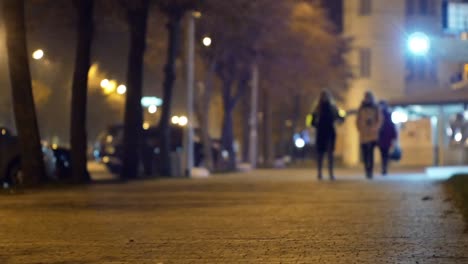 cinematic bokeh with night city street and people in the light of headlights and lanterns