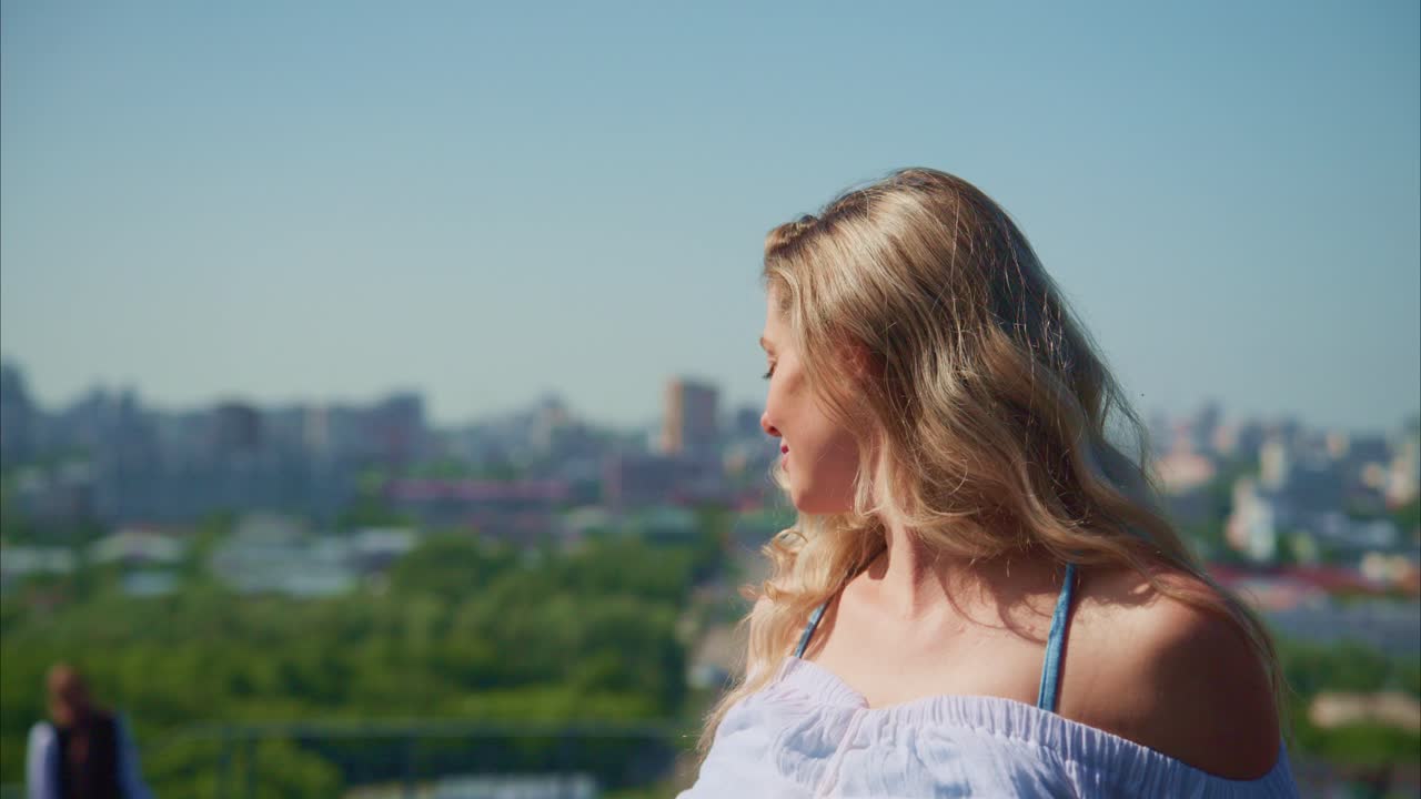 Young Blonde Woman Enjoying Sun and City View on Rooftop