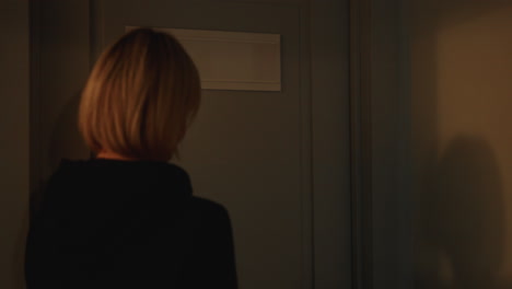 guest knocks on door then enters bright white treatment room smiling as beauty expert in navy uniform opens and closes door behind, sharing warm friendly greeting before skin massage service begins