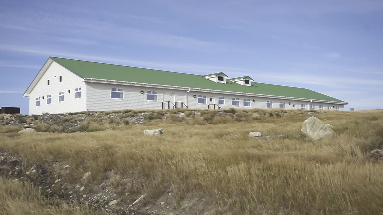 Research station building with a green roof located in antarctica on king george island under a clear blue sky