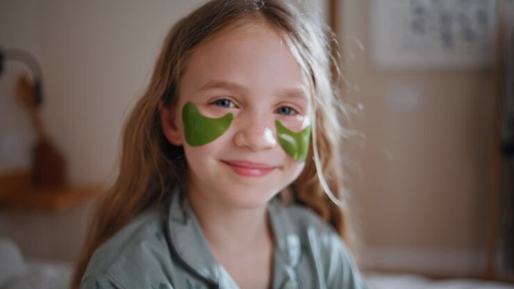Kid using gel patches enjoying skincare closeup. Child looking camera portrait