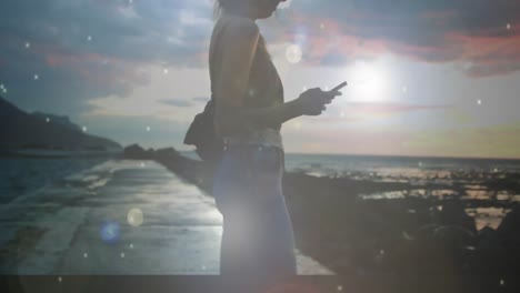 mujer tomando una foto del paisaje de la playa
