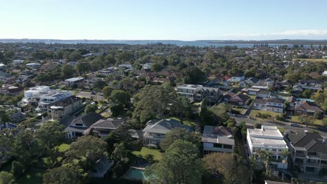 vista aérea del barrio residencial en otoño con el océano en el horizonte