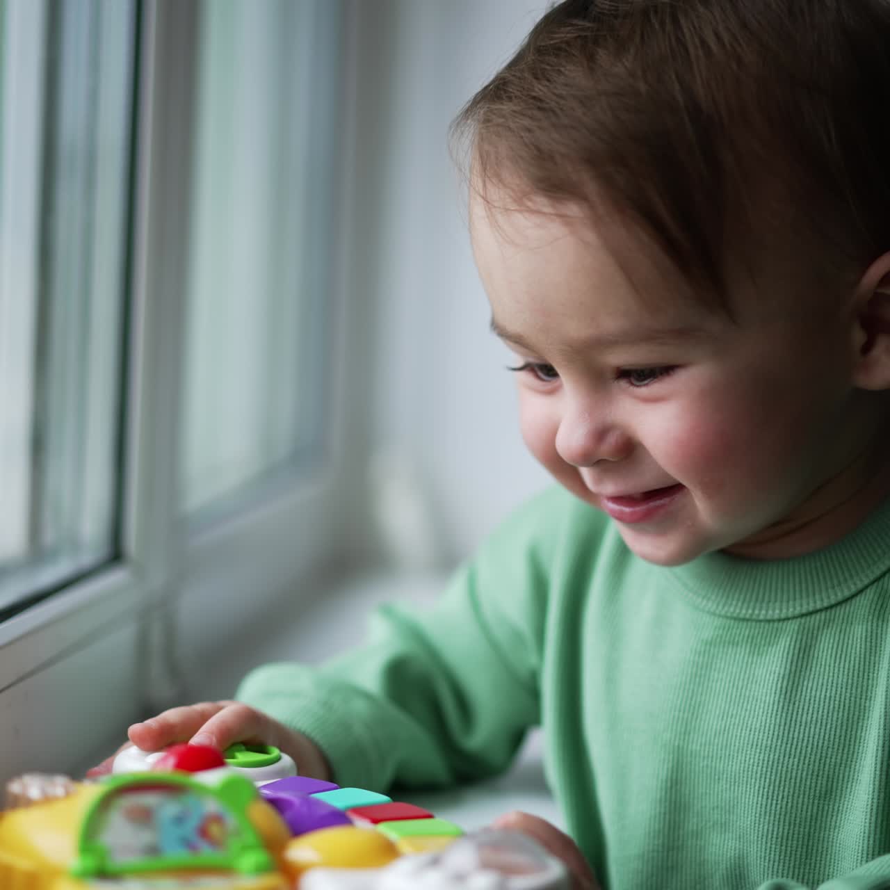 Bambino piccolo e carino che gioca con i giocattoli. Neonata che si diverte a casa