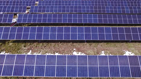 Low-forward-aerial-of-panels-at-enormous-solar-power-farm-in-Michigan