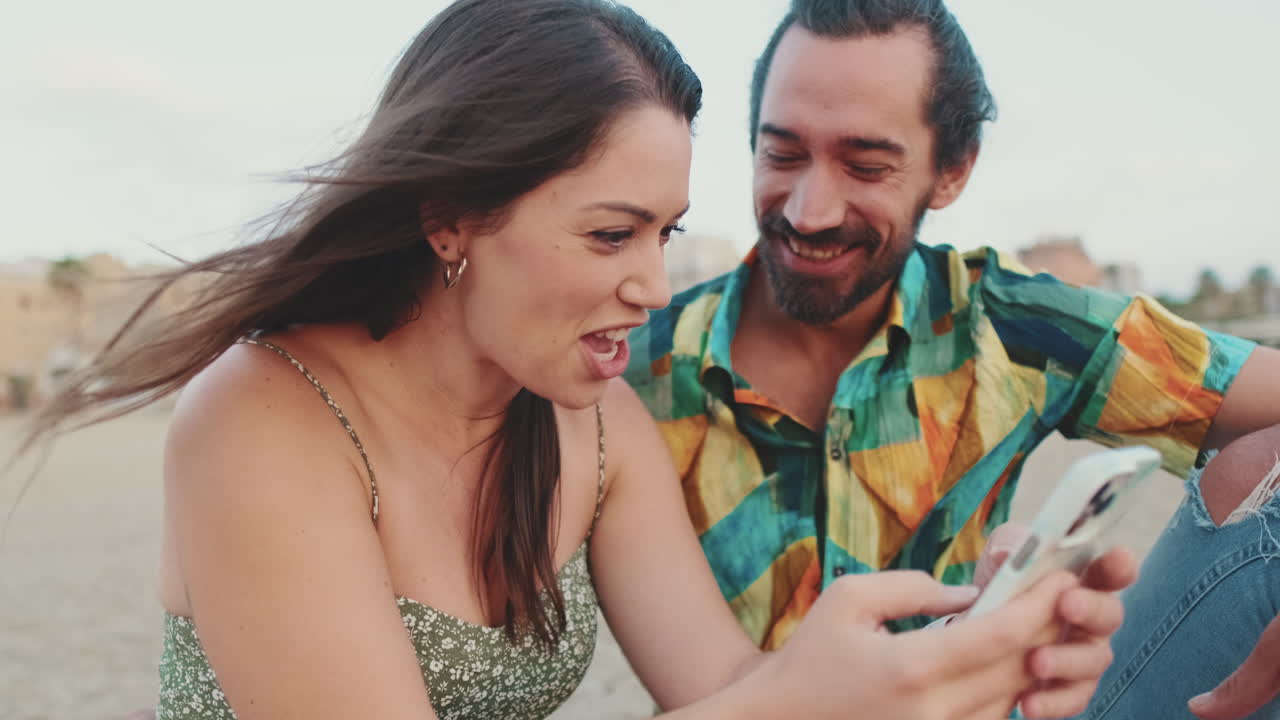Couple looking at a phone on the beach