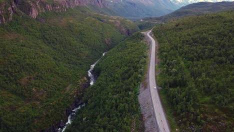 Allein-Unterwegs-Auf-Langer-Straße-Parallel-Zum-Fluss-Im-Grünen-Tiefen-Tal,-Nordnorwegen