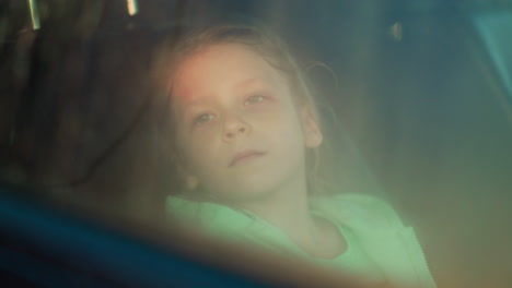 una chica joven mirando por la ventana del coche.