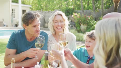 Happy-caucasian-family-having-dinner-and-drinking-wine-in-garden