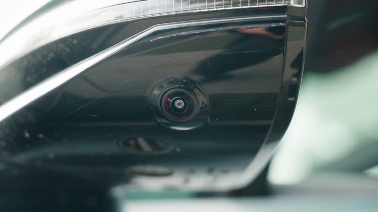Ripresa al rallentatore di una telecamera sotto lo specchietto laterale e del sensore ADAS montati su un moderno veicolo elettrico in Cina
