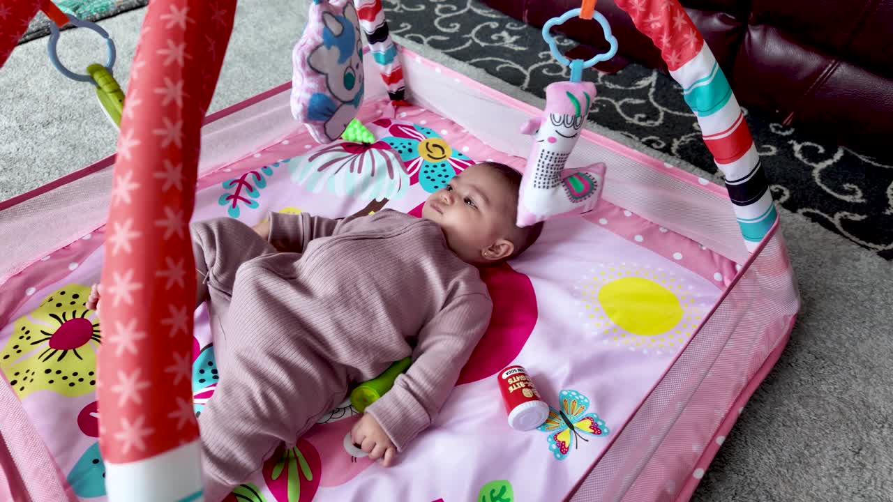 Charming baby enjoying playtime on a vibrant and colorful activity playmat