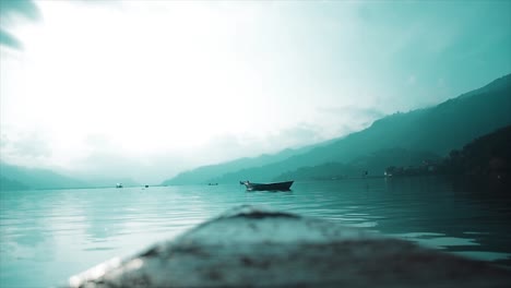 A-pan-shot-of-a-lake-from-the-bow-of-a-wooden-boat