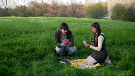 couple playing cards in a park