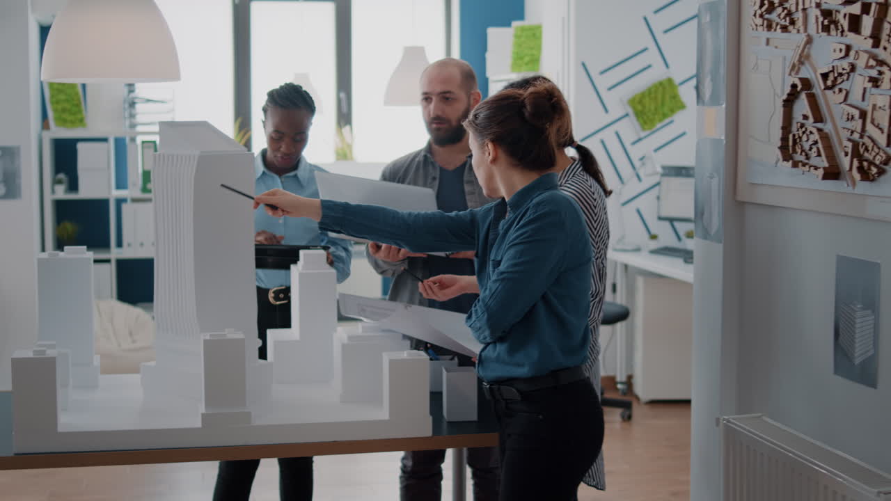 Architects discussing building model and planning a project in the office