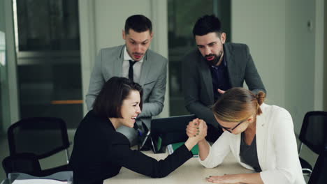 team celebrating arm wrestling victory in office