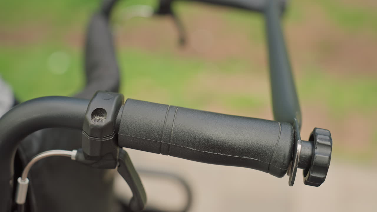 Handle Close Texture, Detailed Image Of Wheelchair Handle And Components On Peaceful Pathway, Closeup Of Wheelchair Handle Showcasing Textured Rubber Grip And Durable Construction Features