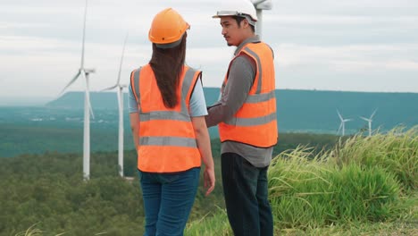concepto progresivo de los ingenieros que trabajan en el parque eólico en la cima de la montaña.